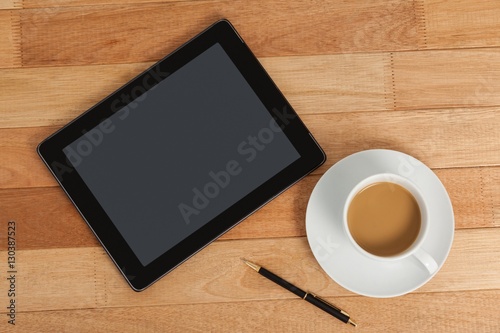 Digital tablet with pen and cup of tea