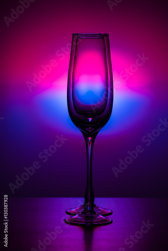empty champagne glass on colored spot background