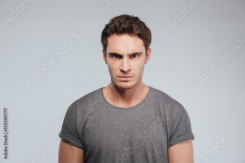 Close up of angry irritated young man looking camera photo