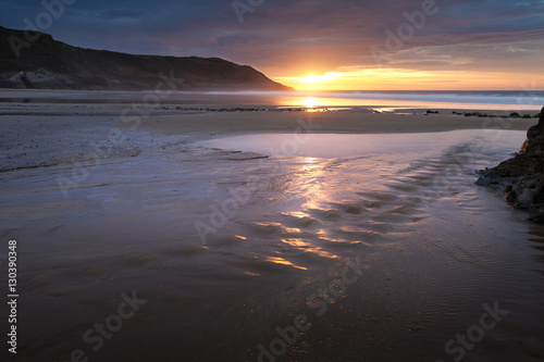 Sunrise over a beach stream at Caswell Bay  one of the most popular and easily accessible beaches on the Gower peninsula in Swansea  