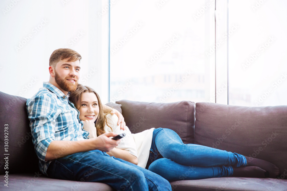 Couple watching TV on the sofa at home