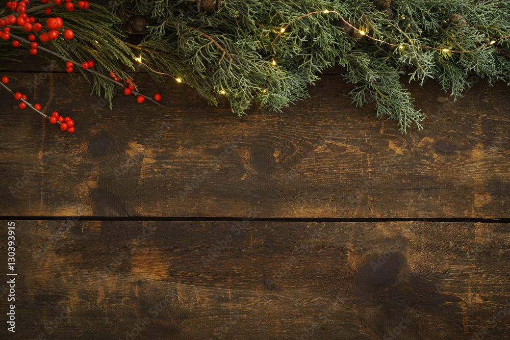 Φωτογραφία Wooden Christmas background with fir green, fir cones and fairy lights