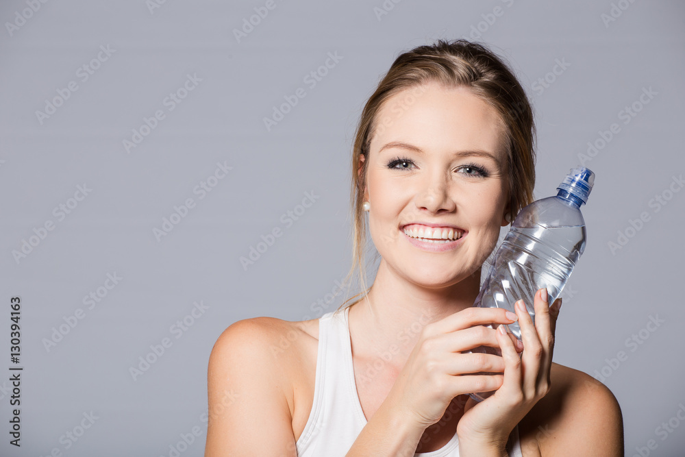 Female fitness model with water bottle on white background. Female fitness model with water bottle on white background.