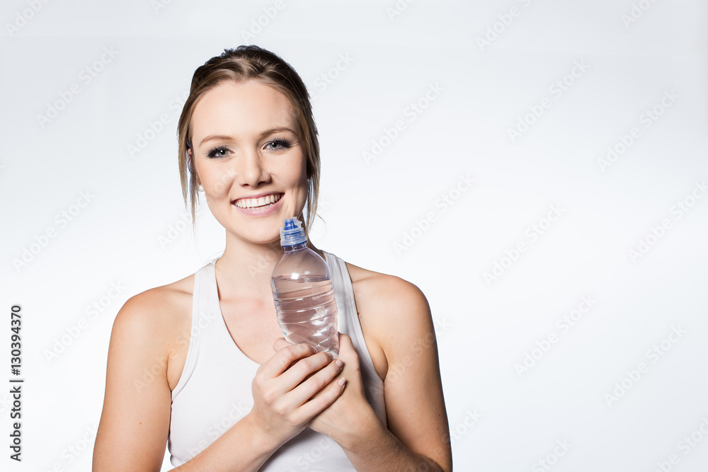 Female fitness model with water bottle on white background. Female fitness model with water bottle on white background.