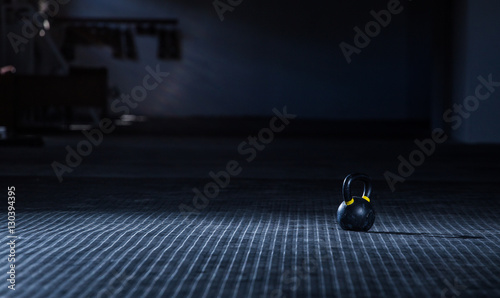 Kettle bell weight in a dark gym with moody and edgy lighting
