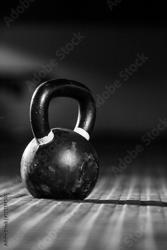 Kettle bell weight in a dark gym with moody and edgy lighting