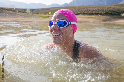 Female triathlete swimming in a dam while competing in a triathlon photo