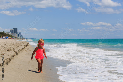 happy cute little girl walk go swim at beach