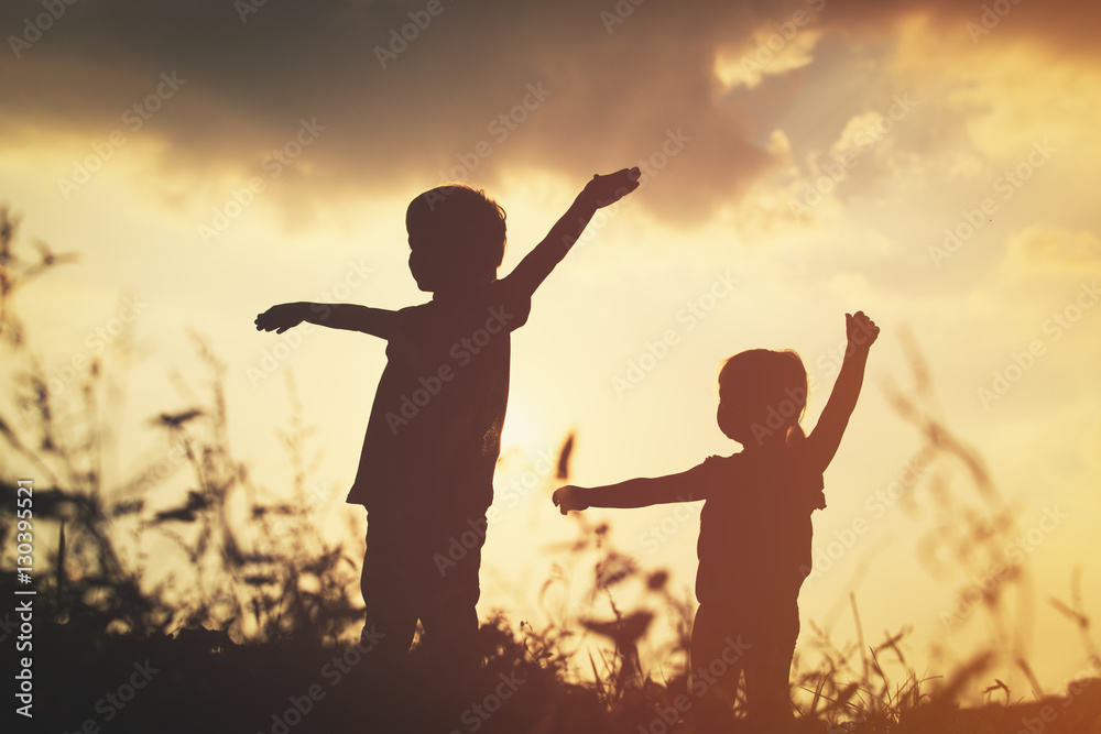 little boy and girl silhouettes play at sunset little boy and girl silhouettes play at sunset
