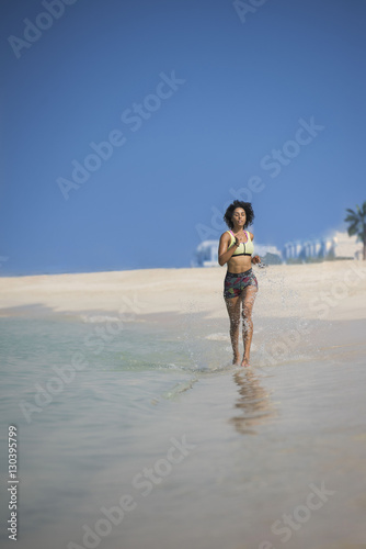 mixed race girl running on beach