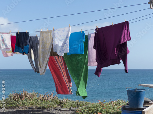 Colorful laundry on a line hanging at the seaside in the wind fo