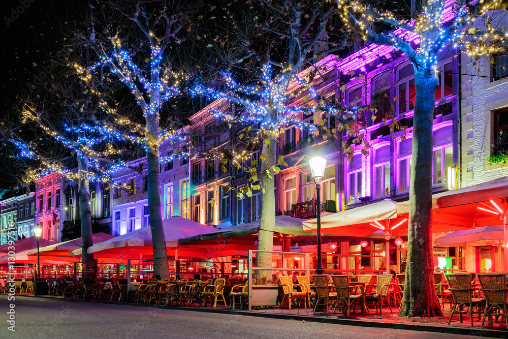 Naklejka premium Bars and restaurants with christmas lights on the famous Vrijthof square in Maastricht