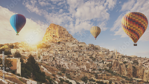 Ancient town and a castle of Uchisar dug from a mountains with hot air balloons flying over Goreme cappadocia.