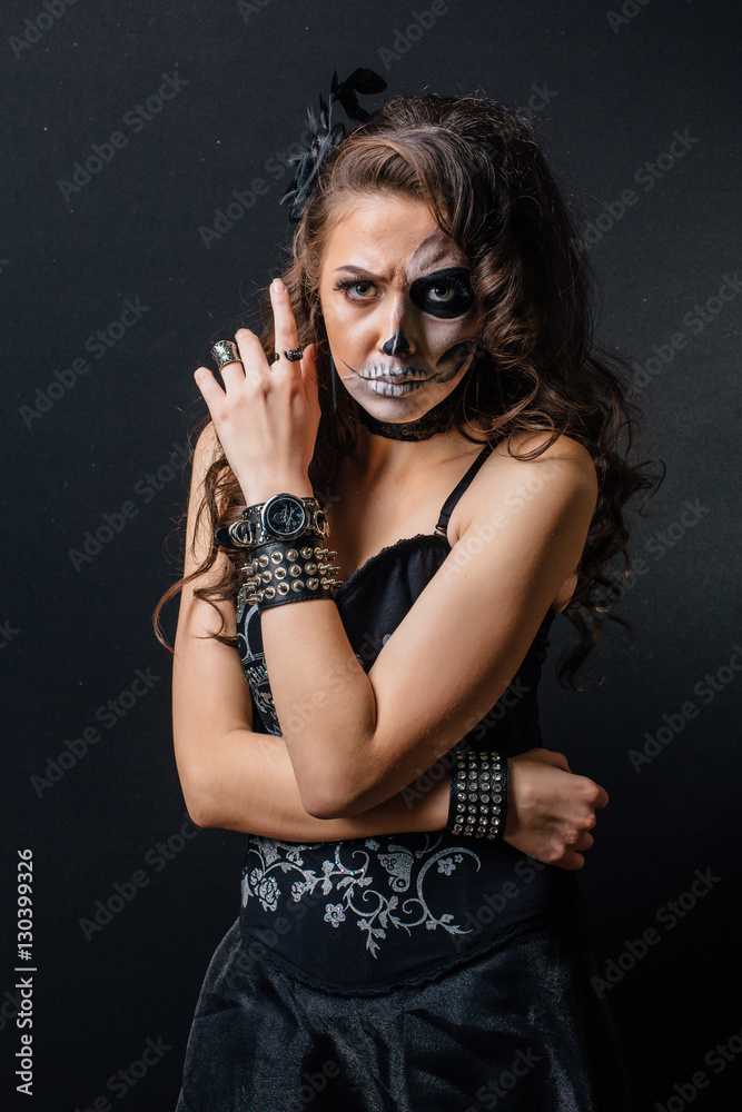 Portrait of young woman with skull make-up.