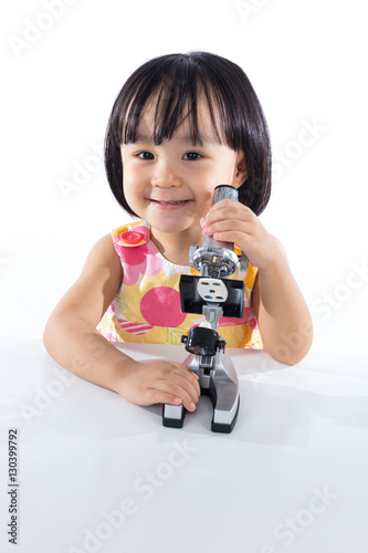 Happy Asian Chinese little girl with microscope