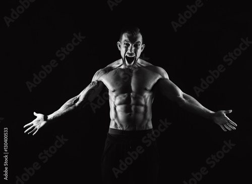 Strong athletic man with naked muscular body screaming