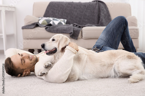 Handsome man with dog  lyin...