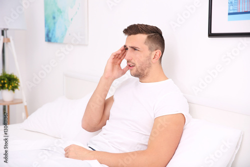 Young man feeling headache at home