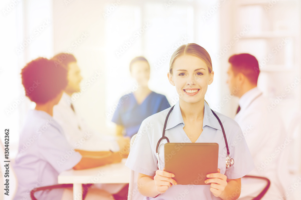 happy doctor with tablet pc over team at clinic happy doctor with tablet pc over team at clinic