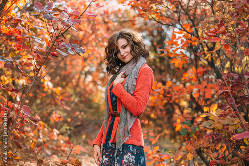 Luxurious lady in colorful dress.A nice  playful smile.Beautiful dress  a scarf wraps her neck it.Fabulous Golden autumnal.Picturesque nature.Fantastic shooting.Fashionable toning.Creative color.