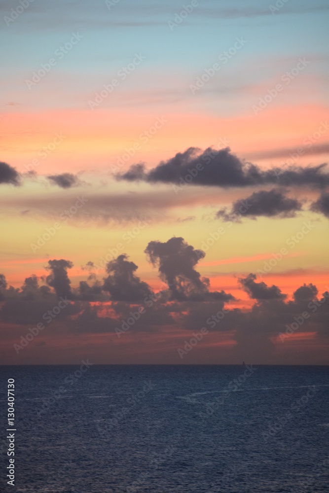 Fototapeta premium Dramatischer und farbenreicher, intensiver Sonnenuntergang über dem Meer