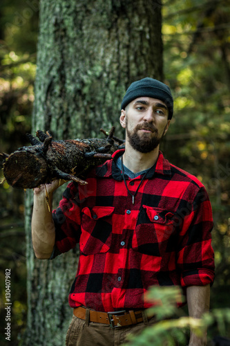 portrait of a man - lumberjack with an ax in the forest, front view