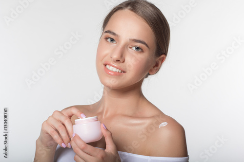 Girl is holding jar with moisturizing cream