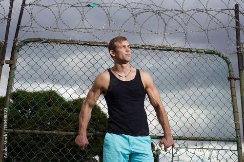 A Close up view of a good looking male model leaning and holding © Dewald