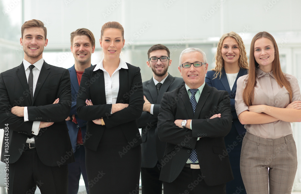 Mature businessman and cheerful business team on office backgrou Mature businessman and cheerful business team on office backgrou