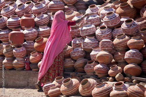 Indian woman selling clay water pots on sale in old town Udaipur, Rajasthan, Western India,