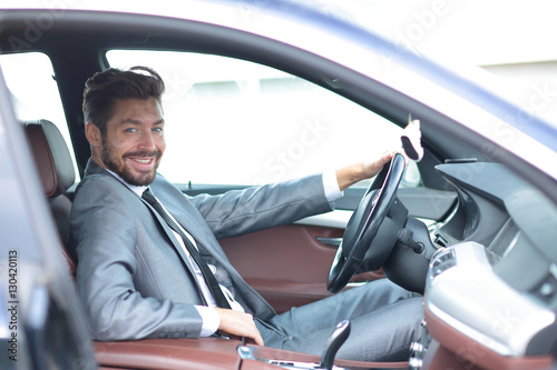 Portrait of an handsome smiling business man driving his car