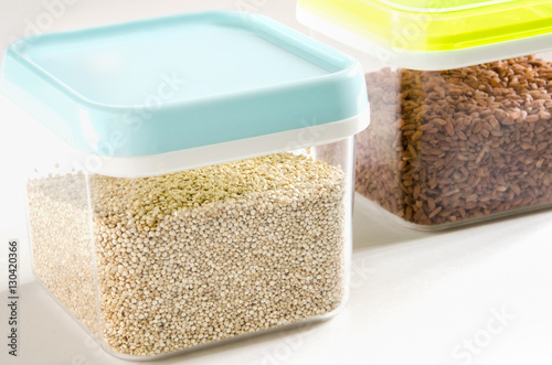 Food storage. Food ingredients (quinoa and brown rice) in plastic containers. Selective focus.