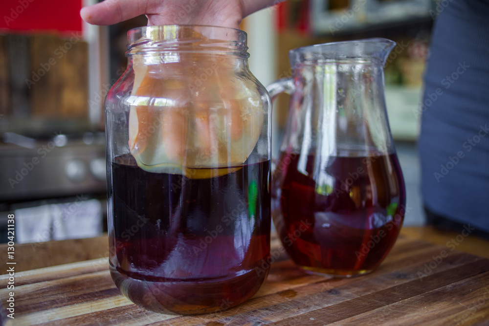 close up image of the step by step way to prepare kombucha tea using a live bacteria culture, scobie and black tea in a real life kitchen close up image of the step by step way to prepare kombucha tea using a live bacteria culture, scobie and black tea in a real life kitchen