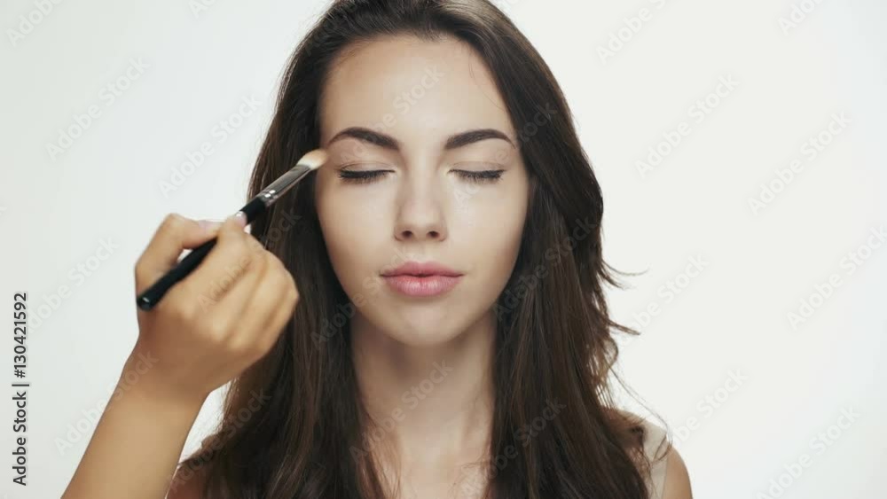 Make up artist applying eyeshadow on eyelid of a female model
Make up artist applying eyeshadow on eyelid of a female model