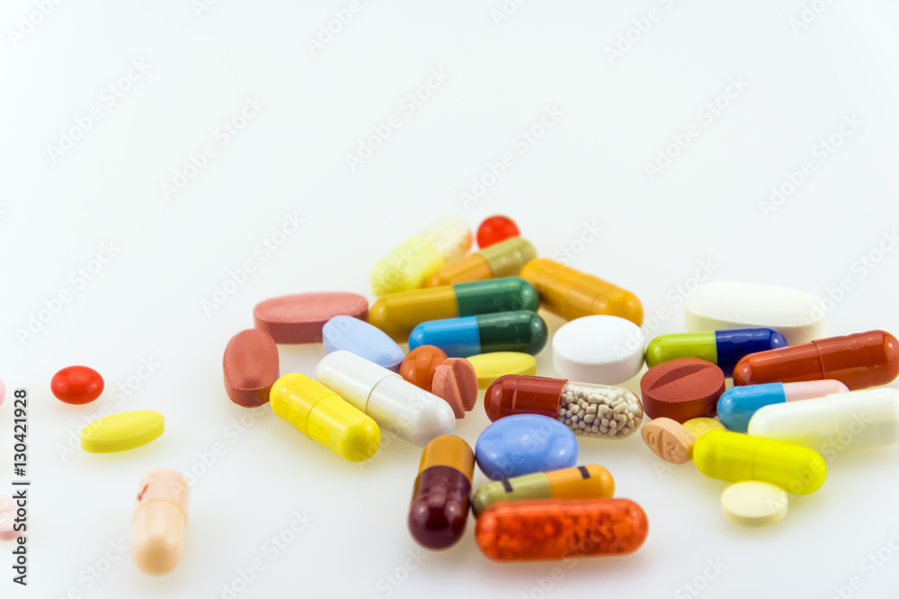 Many colored tablets and capsules isolated on white background. Many colored tablets and capsules isolated on white background.
