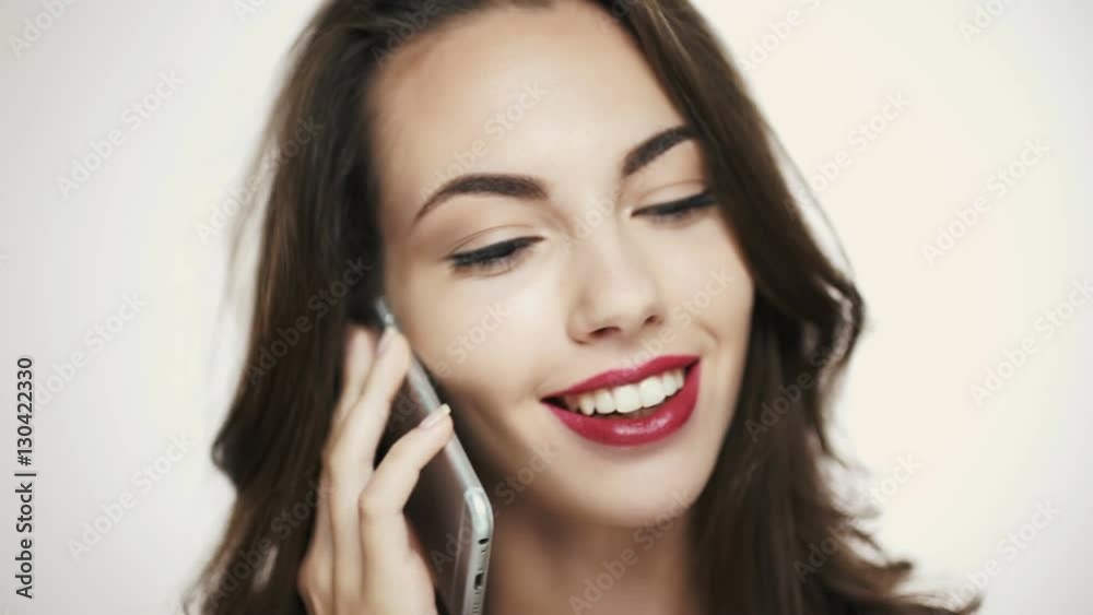 Smiling young brunette woman with purple lipstick talking on mobile phone Smiling young brunette woman with purple lipstick talking on mobile phone
