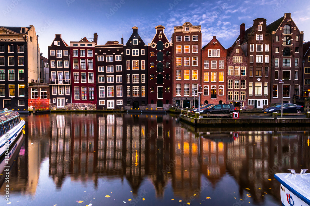 Night city view on Amsterdam canal. Facade and reflections in canal. Netherlands 