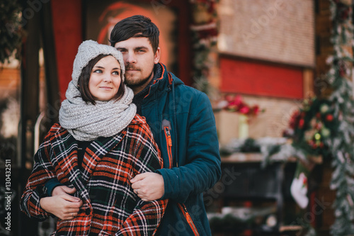 Happy couple in warm clothes posing on a Christmas market. Holiday mood