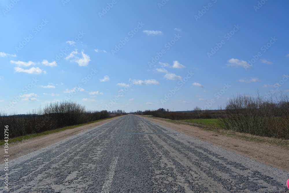 Fototapeta premium Beautiful spring rural landscape: road in the clouds, nature, countryside