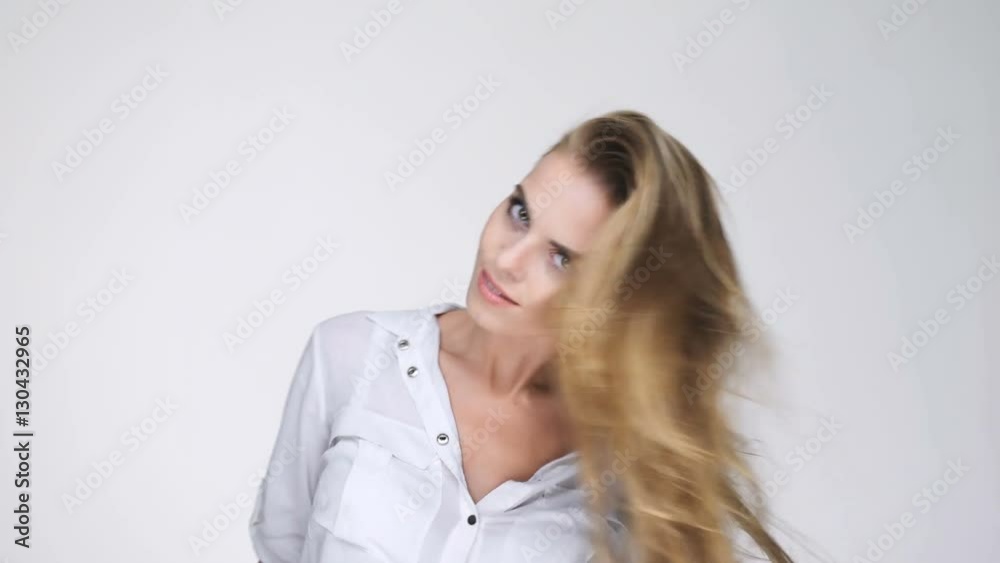 Atractive young blonde woman with long hair shaking head and looking at camera Atractive young blonde woman with long hair shaking head and looking at camera