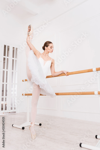 Sporty young woman holding her leg upwards