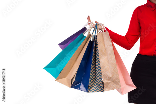 Colourful and bright shopping packages hanging on female right hand