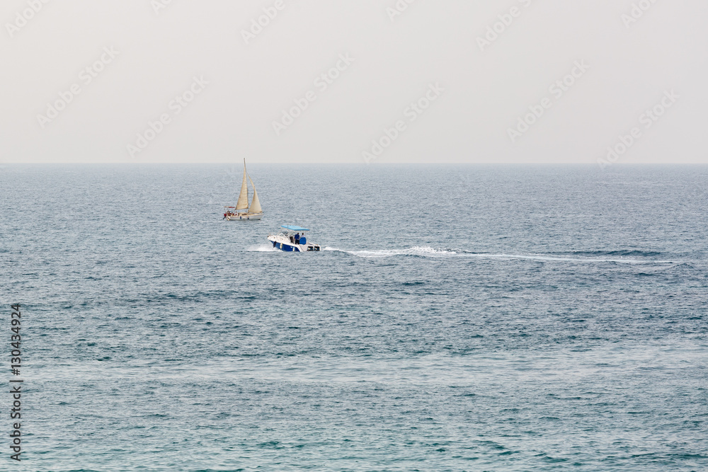 Obraz premium One sailing and one motor boats at the sea
