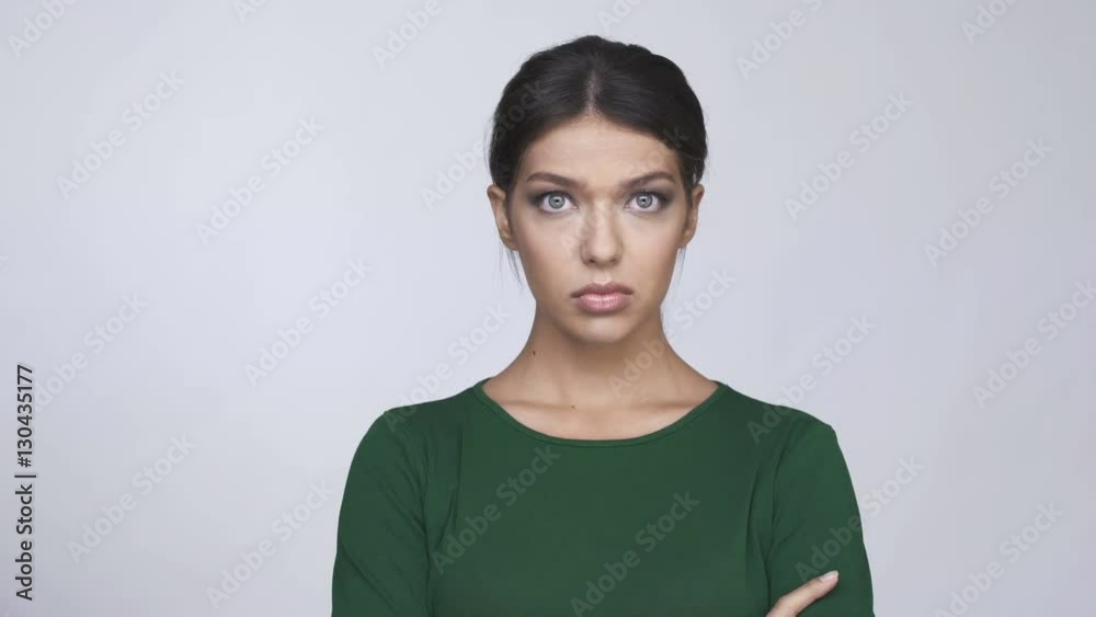 Upset sad young brunette woman in green sweater looking at camera Upset sad young brunette woman in green sweater looking at camera