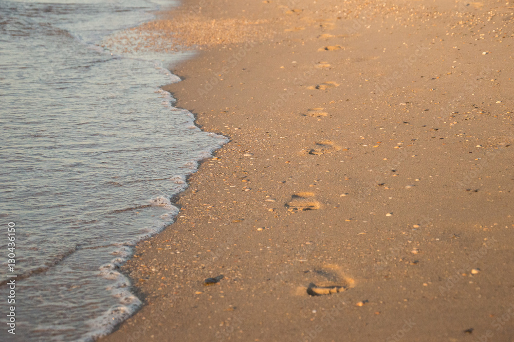 Footsteps on the beach by the sea