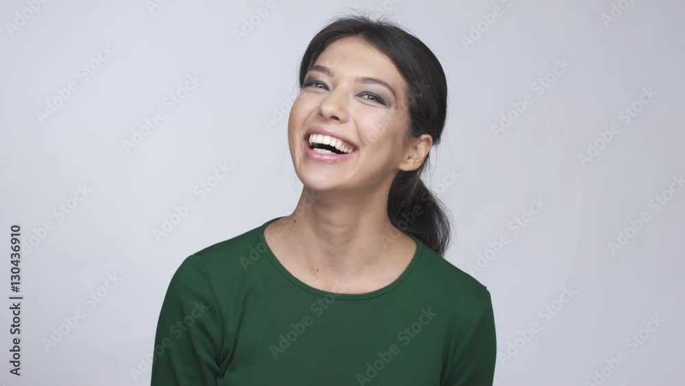 Cherful young woman in green sweater showing dollar bills and throwing it away Cherful young woman in green sweater showing dollar bills and throwing it away