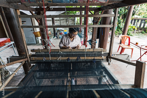 Tai Lue (Lu) indigenous weaver at a wooden loom weaving Tai Lue traditional clothing, Chiang Mai photo