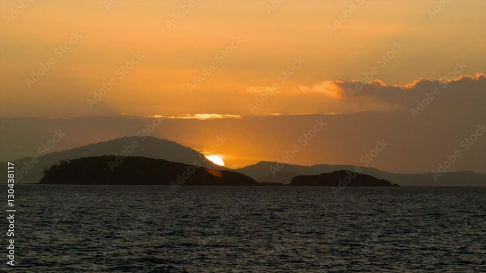 At Sea Vibrant Golden Orange Sunrise Sunset Over Dark Mountain Fjords Seen from a Moving Ship on the Ocean Water At Sea Vibrant Golden Orange Sunrise Sunset Over Dark Mountain Fjords Seen from a Moving Ship on the Ocean Water
