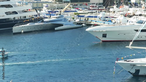 World Fair MYS Monaco Yacht Show, Port Hercules, luxury megayachts, many shuttles, taxi boat, presentations, Journalists, boat traffic, Azur water, aerial view, mountains on background, perspective photo