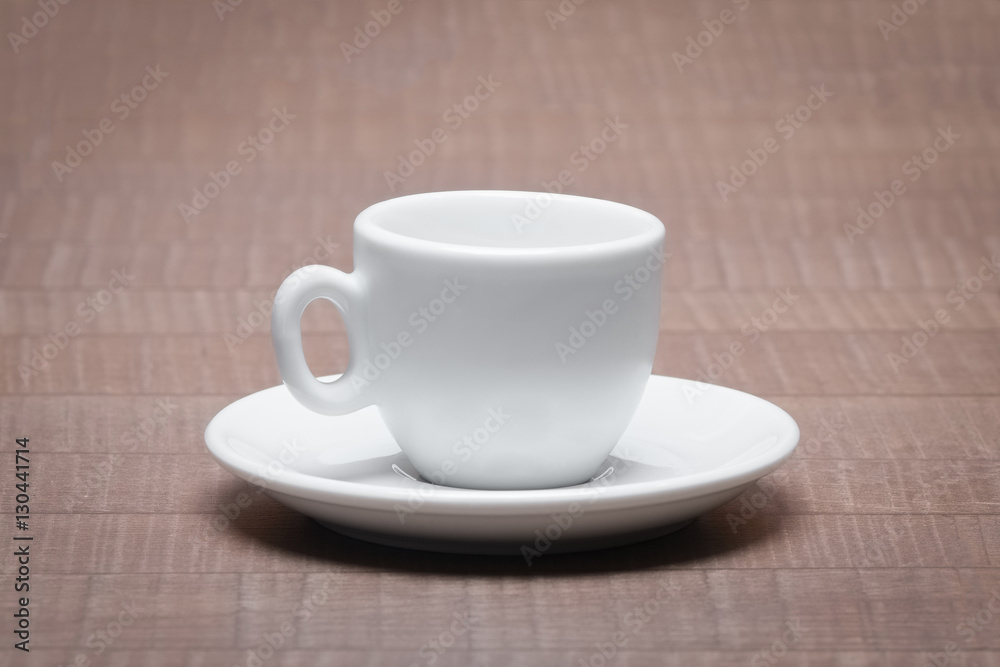 Clean and empty ceramic cup for espresso with saucer on wooden t Clean and empty ceramic cup for espresso with saucer on wooden t